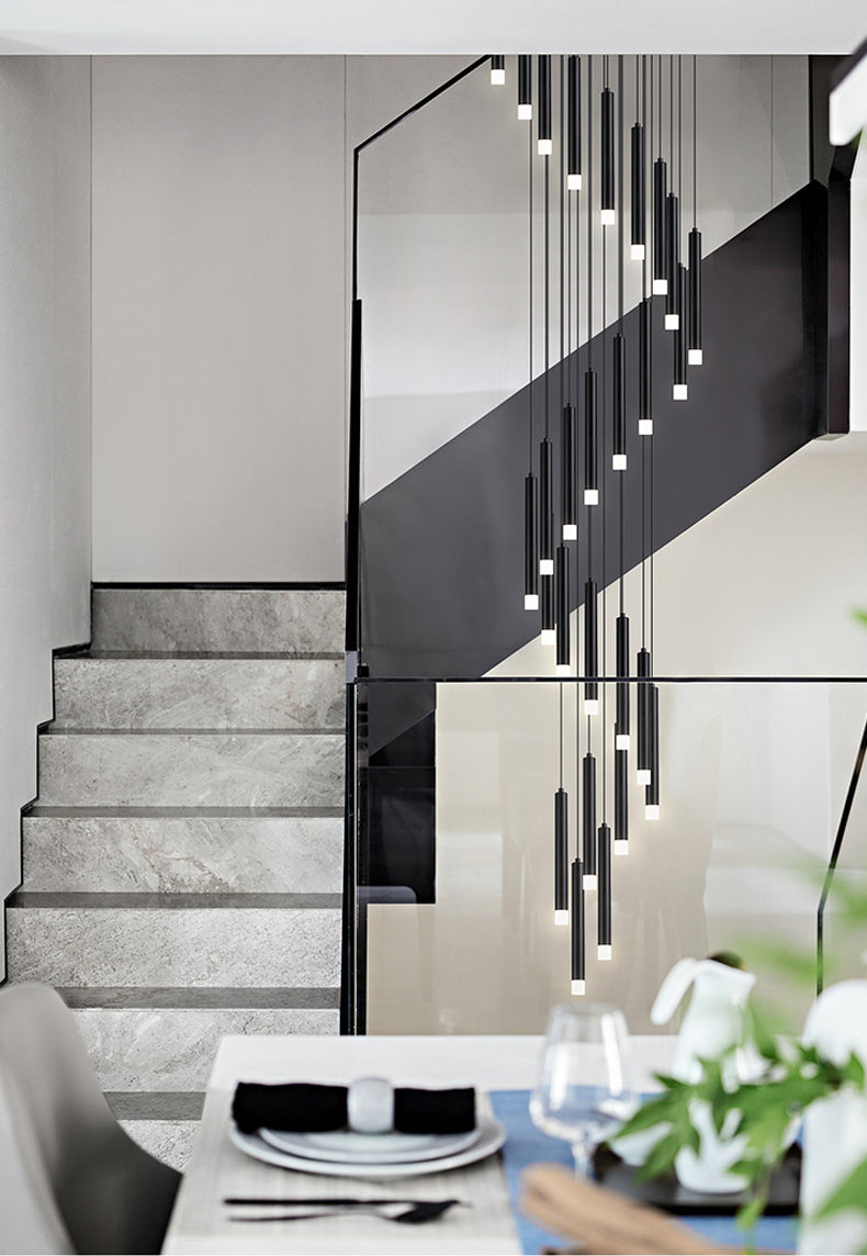 The Black LED Pendant light hanging above modern black and white staircase, illuminating the sleek design.