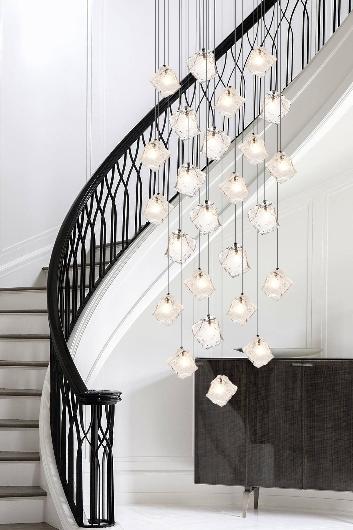 A beautifully designed staircase with a shimmering pendant light above, exuding elegance and charm.