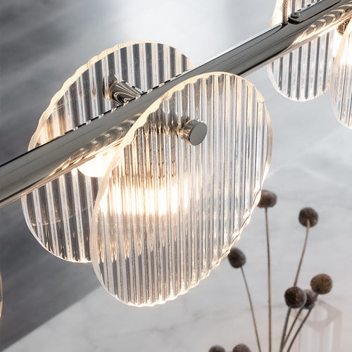 A sleek modern light fixture featuring multiple circular lights, emitting a soft, warm glow for an inviting ambiance.