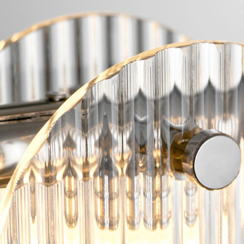  Close-up of a glass wall light mounted on a metal base, radiating a gentle, warm light that adds elegance to the space.