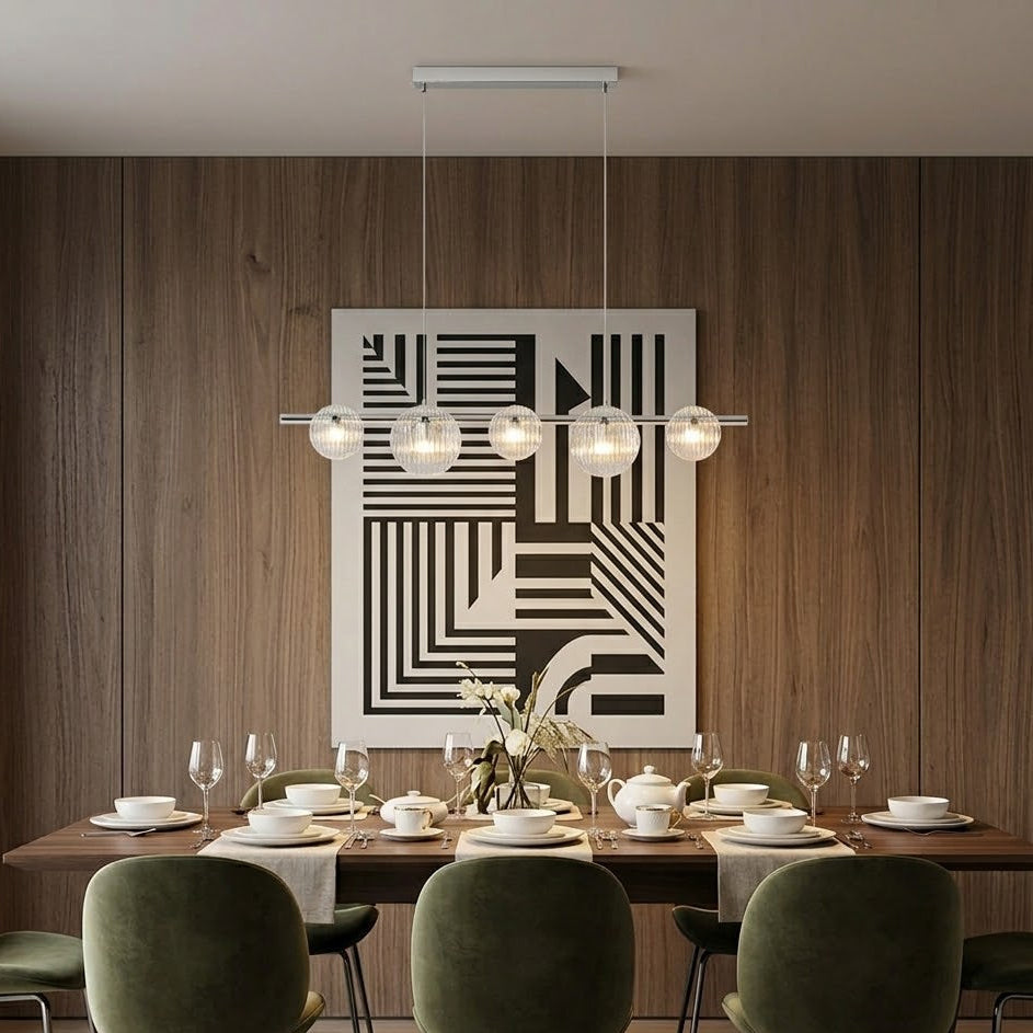 Dining room with a geometric wall art piece, wooden table, and green chairs.